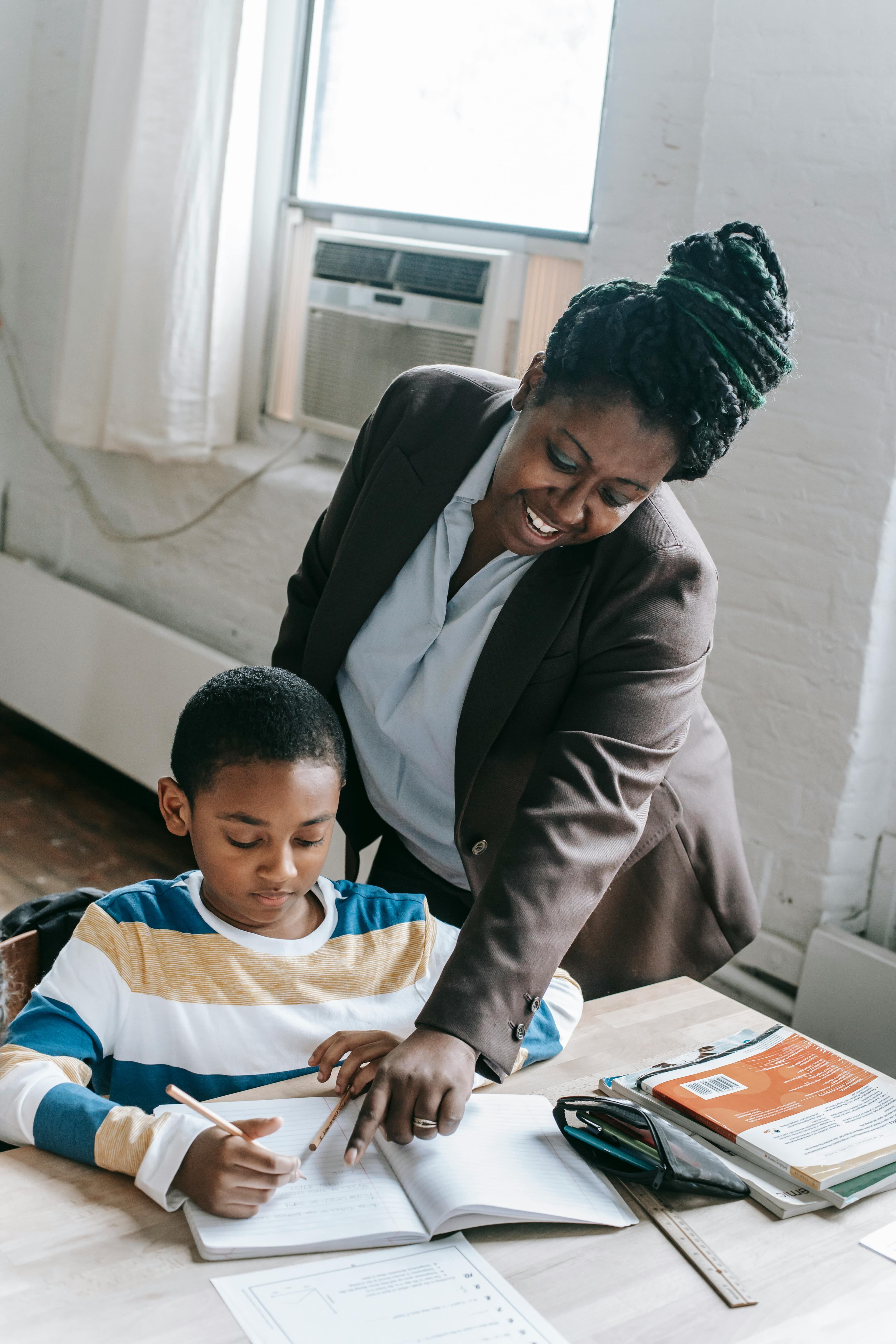 A teacher working with an older student at a table during reading support.